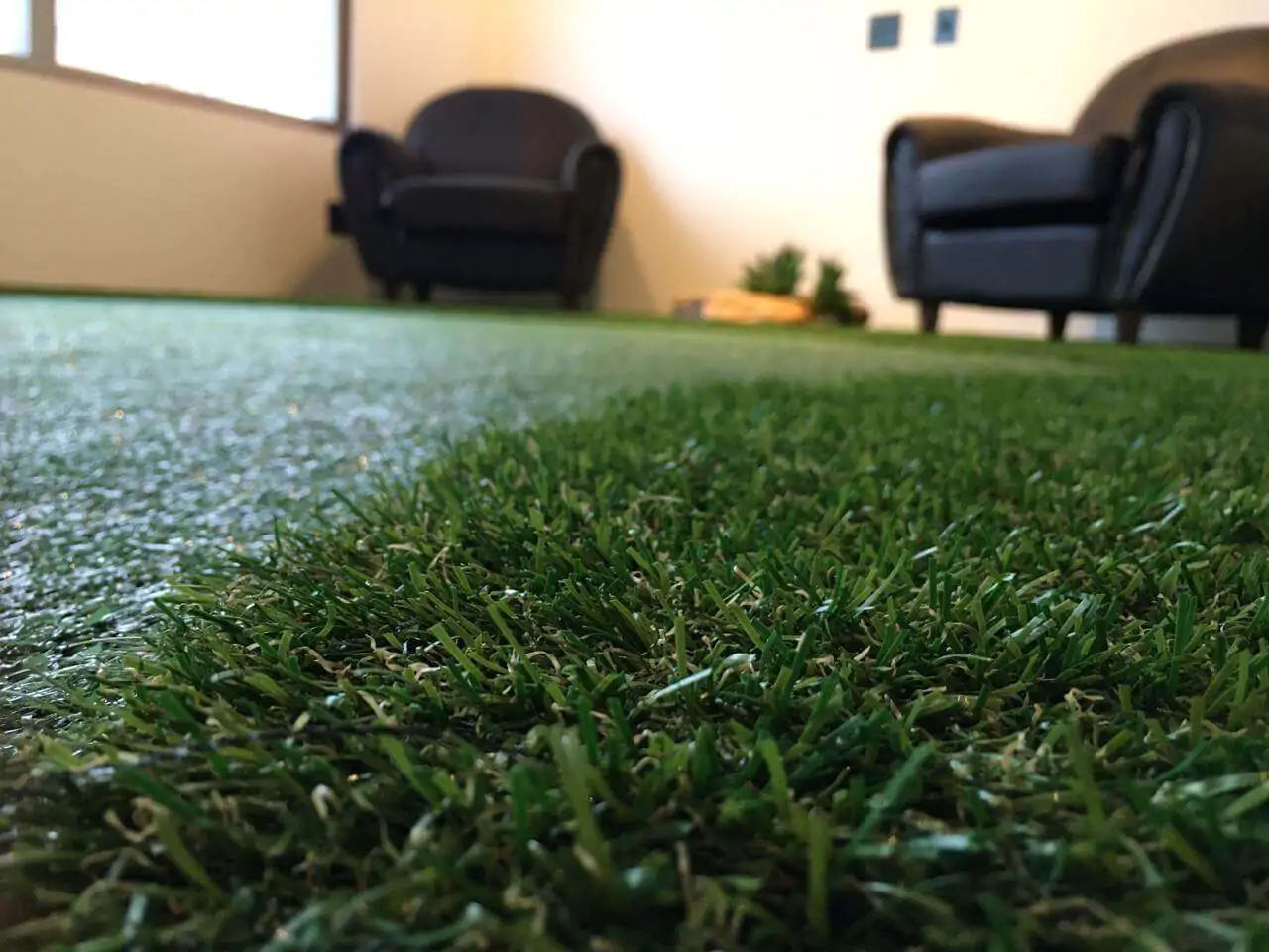 Sala comercial com piso de grama sintética e poltronas