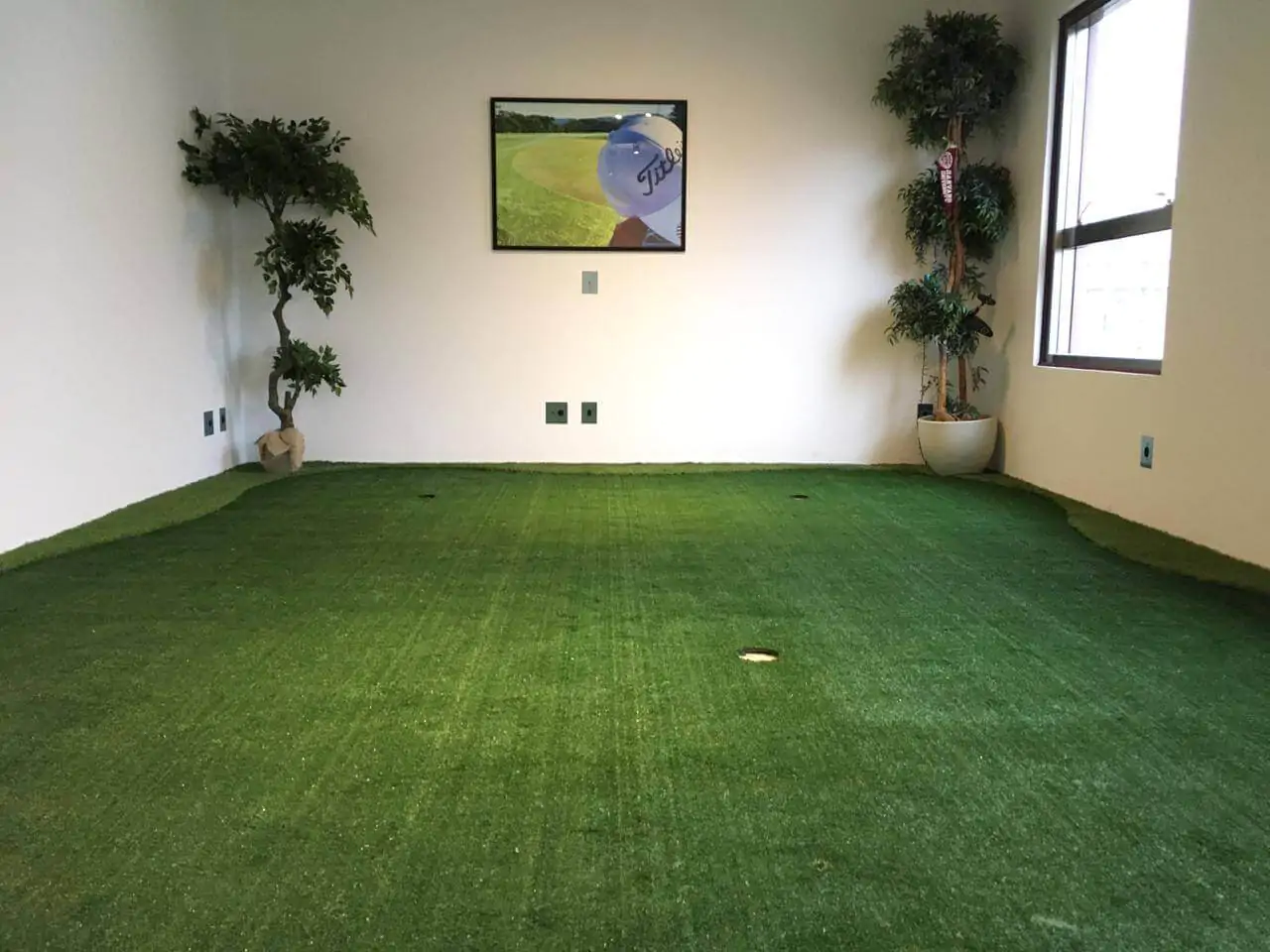 Ambiente interno com putting green de grama sintética para golfe